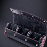 Black velvet watch case with three compartments on a dark background