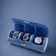 Navy Blue velvet watch roll with three watches on a blue background