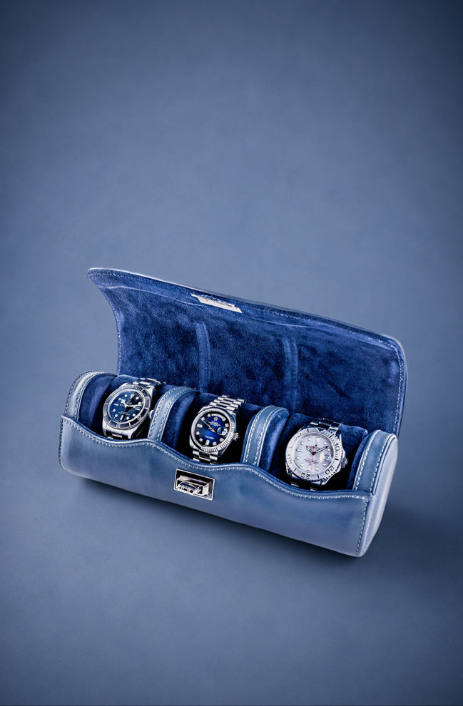 Navy Blue velvet watch roll with three watches on a blue background