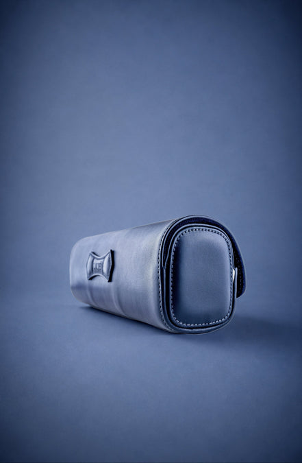Navy Blue leather watch roll with three watches on a blue background